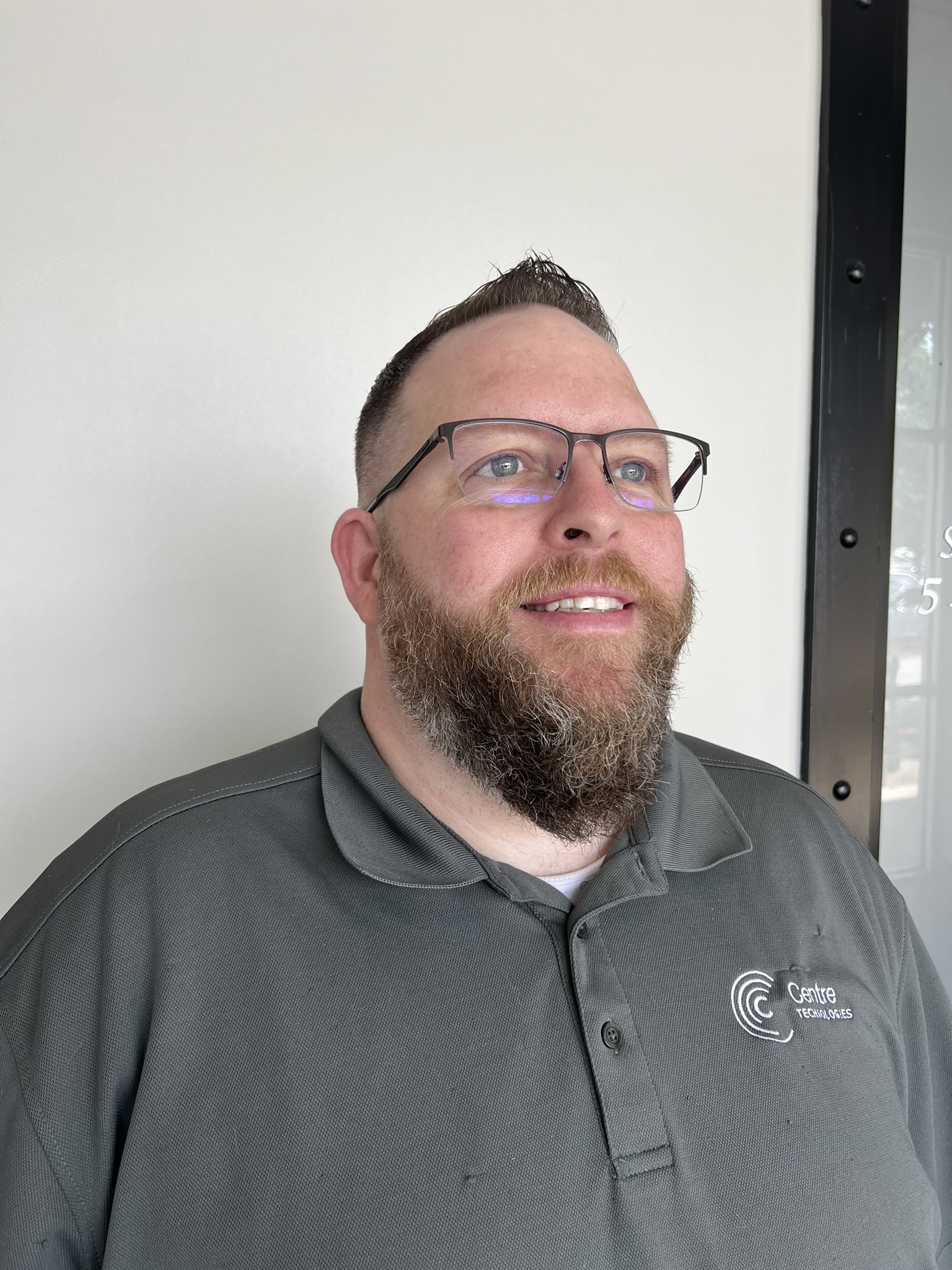 Image of a man with glasses posing at an angle to show haircut and beard trim received from Beard and Beauty's in Cedar Park, Texas